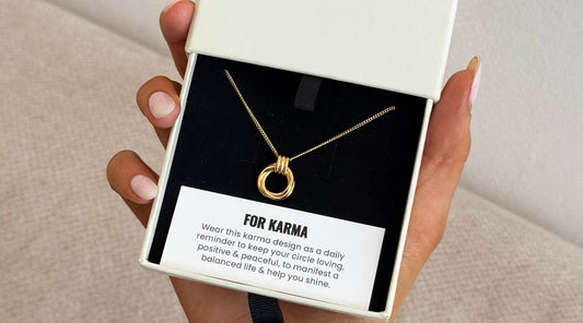 gold karma necklace in a jewellery box with meaning card